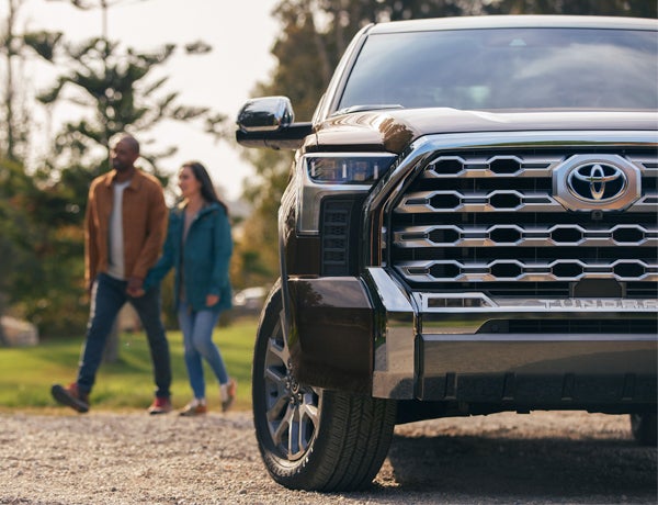 Bennett Toyota is a Toyota Dealership in Allentown near Hellertown, PA | A Coule in the Background Walking Away from the 2022 Toyota Tundra in a Park