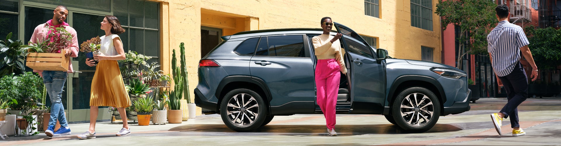 Model Features of the 2022 Toyota Corolla Cross at Bennett Toyota | Woman seen leaving their 2022 Toyota Corolla Cross parked on a Lively Street.