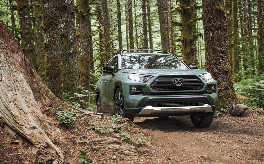 Bennett Toyota of Allentown is a Car Dealership near Wescosville PA | 2020 Toyota RAV4 driving on wooded trail