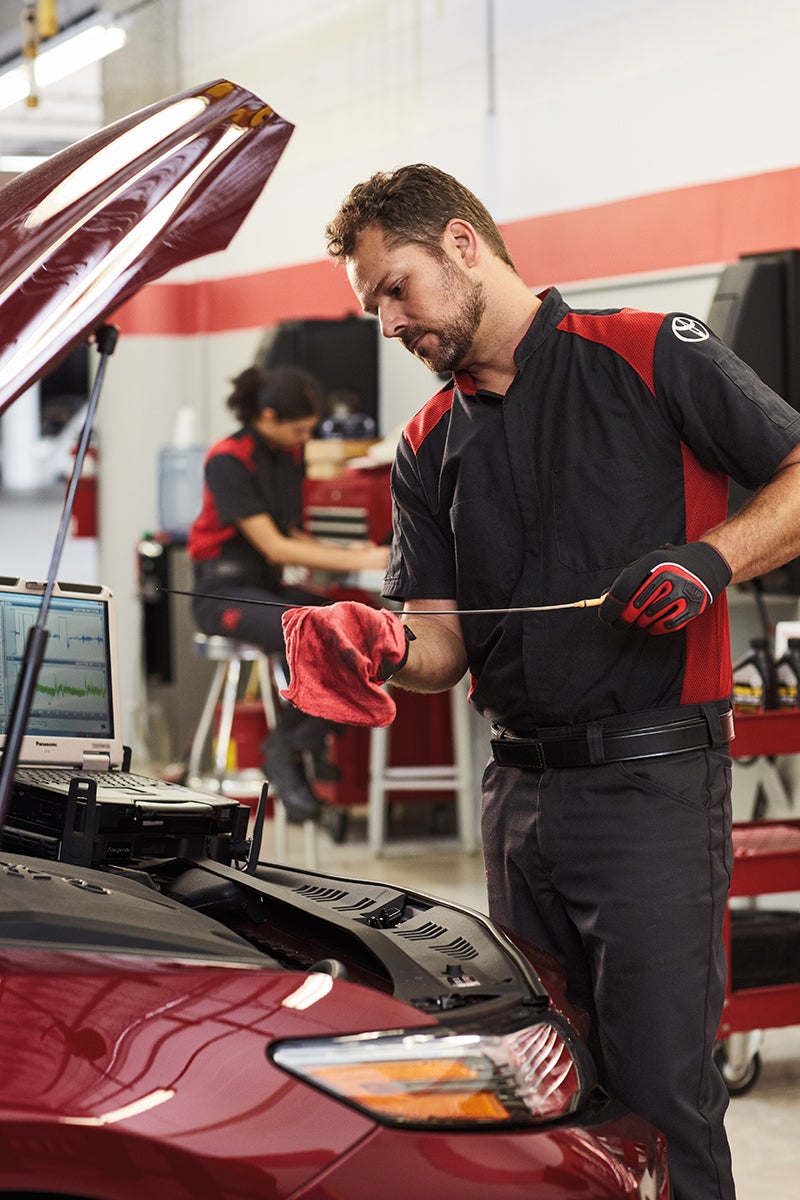 Bennett Toyota of Allentown is a Car Dealership near Fountain Hill PA | Toyota Service Advisor checking oil level in vehicle