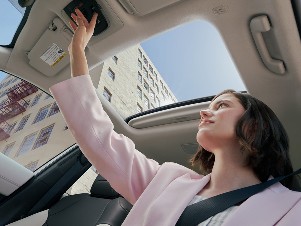 Model Features of the 2022 Toyota Corolla Cross at Bennett Toyota | Woman Adjusting the Sunroof in her Corolla Cross