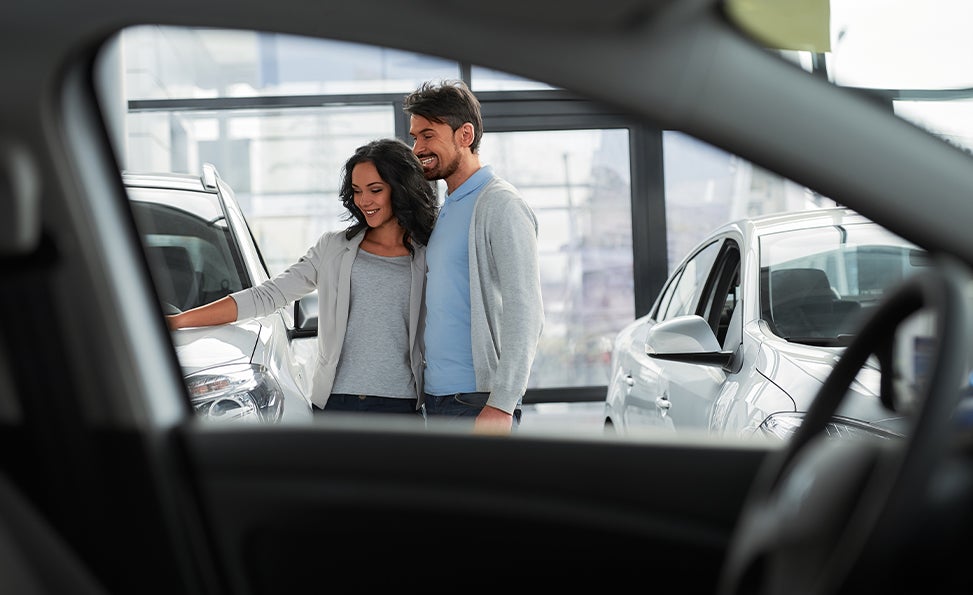 Documents to bring when purchasing a car at Bennett Toyota in Allentownn | Couple looking at new Toyotas in dealer showroom