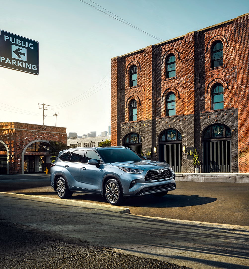 Compare the 2021 Toyota Highlander vs. the 2021 Honda Pilot at Bennett Toyota | 2021 Toyota Highlander parked outside of old building