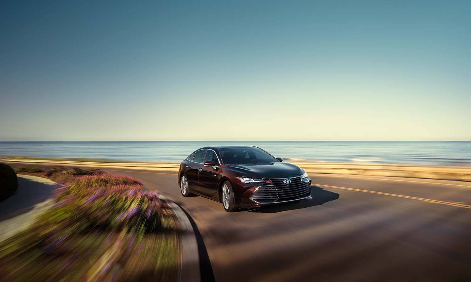 Toyota Hybrid for Everyone at Bennett Toyota | 2022 Toyota Avalon Hybrid driving by the beach