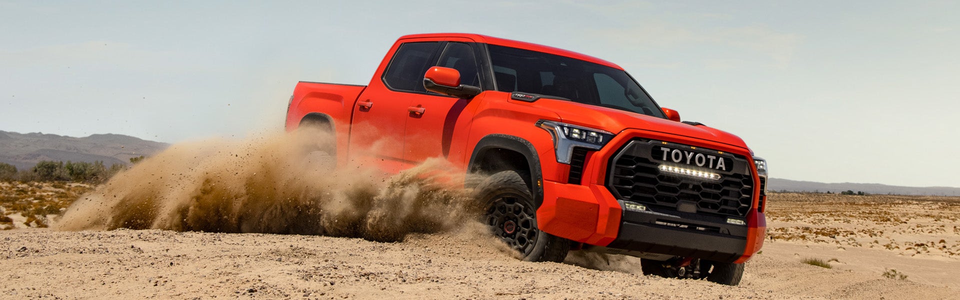 The All-New 2022 Toyota Tundra at Bennett Toyota in Allentown | Red 2022 Toyota Tundra Driving Through Desert